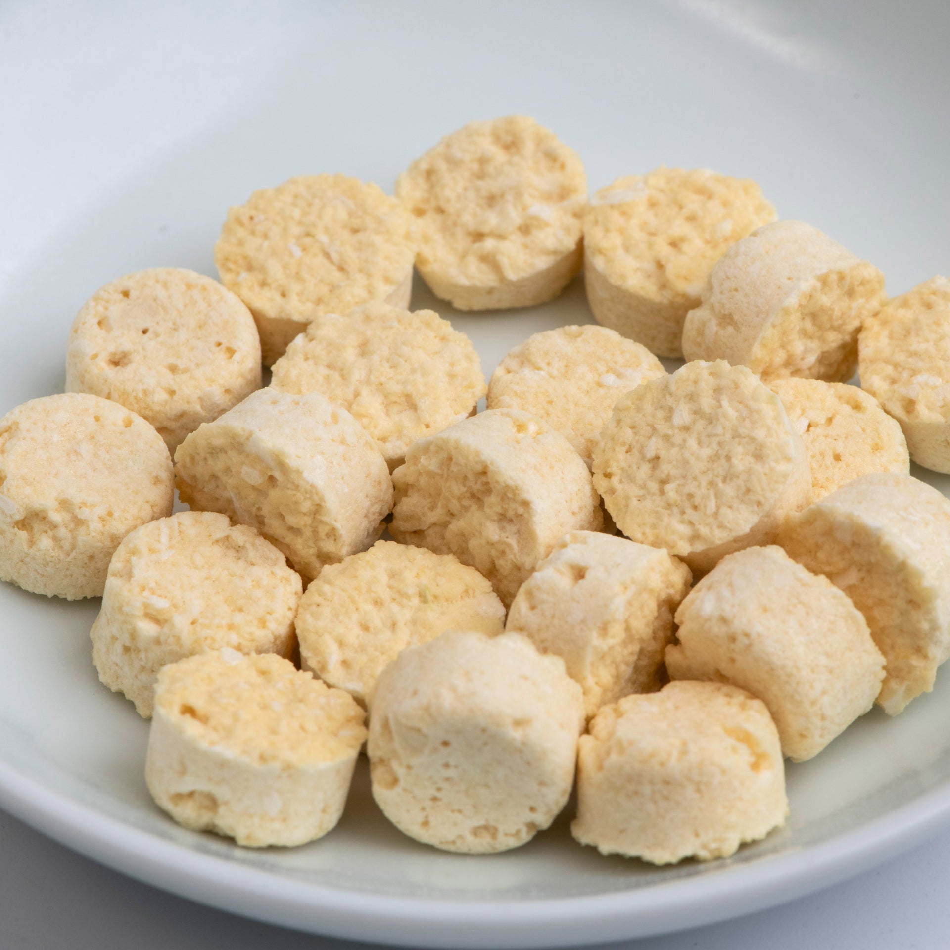 Freeze-dried chopped garlic tablets, beige round pieces in bowl