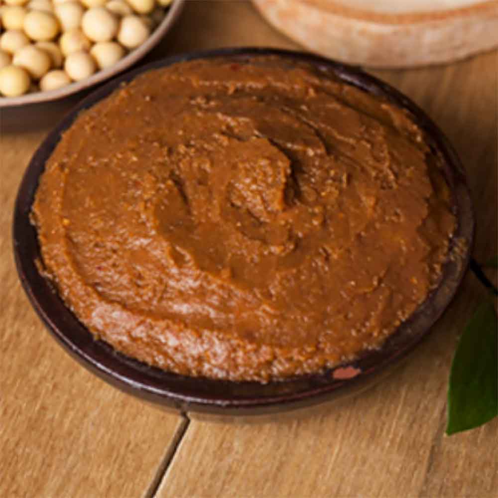 Brown doenjang paste in a bowl, thick textured soy fermentation paste