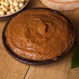 Brown doenjang paste in a bowl, thick textured soy fermentation paste