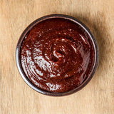 Traditional gochujang paste in small bowl, thick dark red and glossy