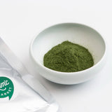 Mugwort powder in white bowl, finely ground green powder