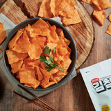 Bowl of crunchy orange kimchi chips with parsley garnish