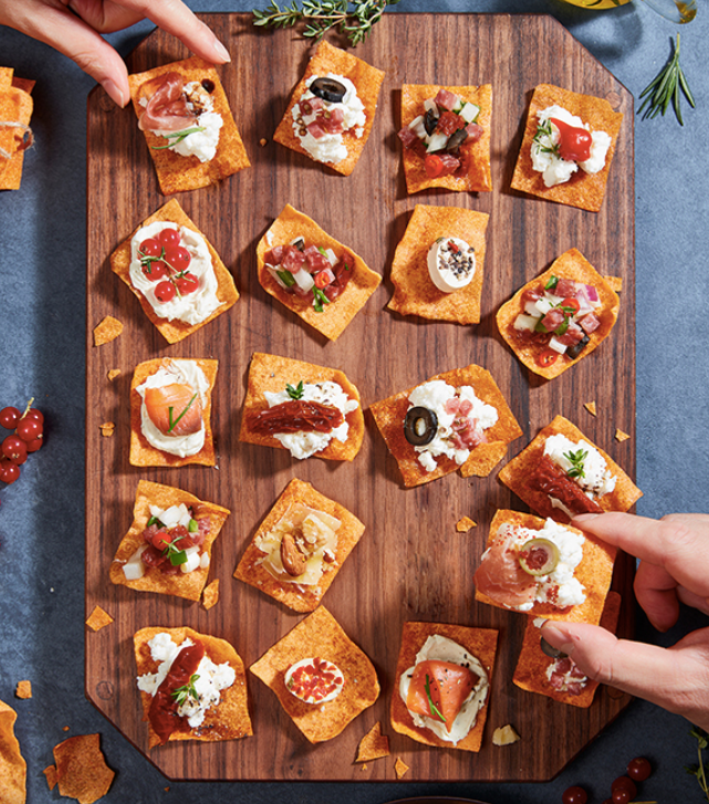Crunchy kimchi chip bites on a wooden board with toppings