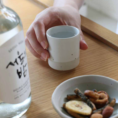 Sando shot cup, light gray-green cup held in hand.