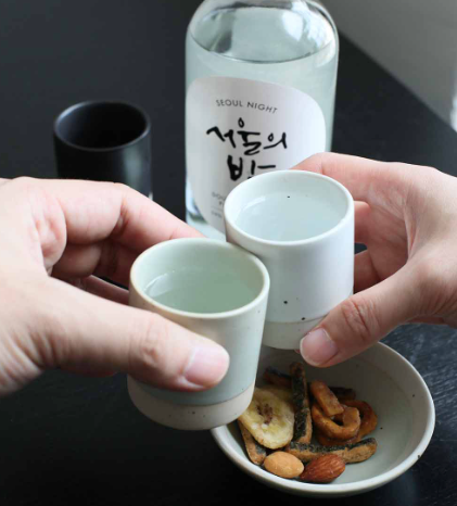 Sando shot cup in use: light green and white cups in hands.