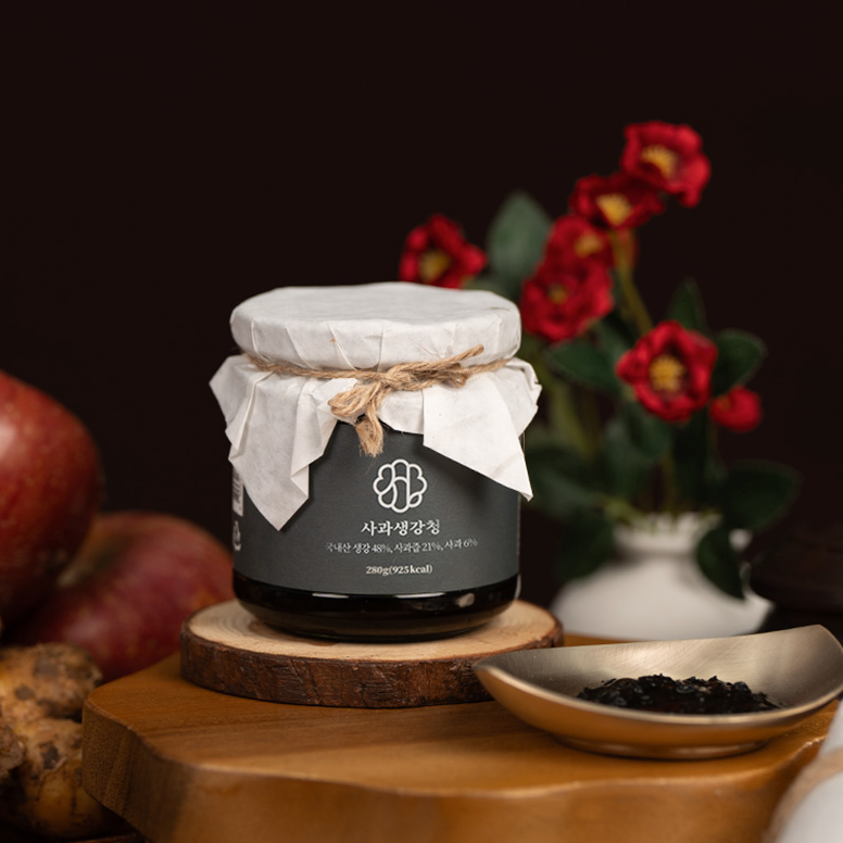 Apple ginger extract jar with fabric wrap and twine on a wooden base, label emblem