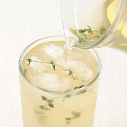 Yuzu juice in a clear glass with ice and mint herb sprigs