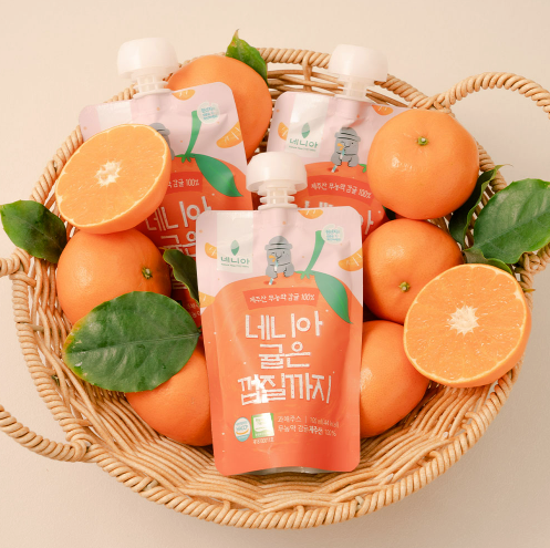 Tangerine juice pouch in basket surrounded by tangerines