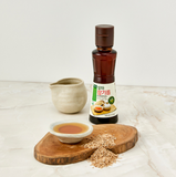 Extra virgin sprouted sesame oil bottle with amber liquid and paper label