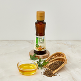 Extra virgin sprouted perilla oil bottle with a small glass of golden oil