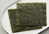 Roasted gimbap laver sheets on a plate, dark green, square pieces