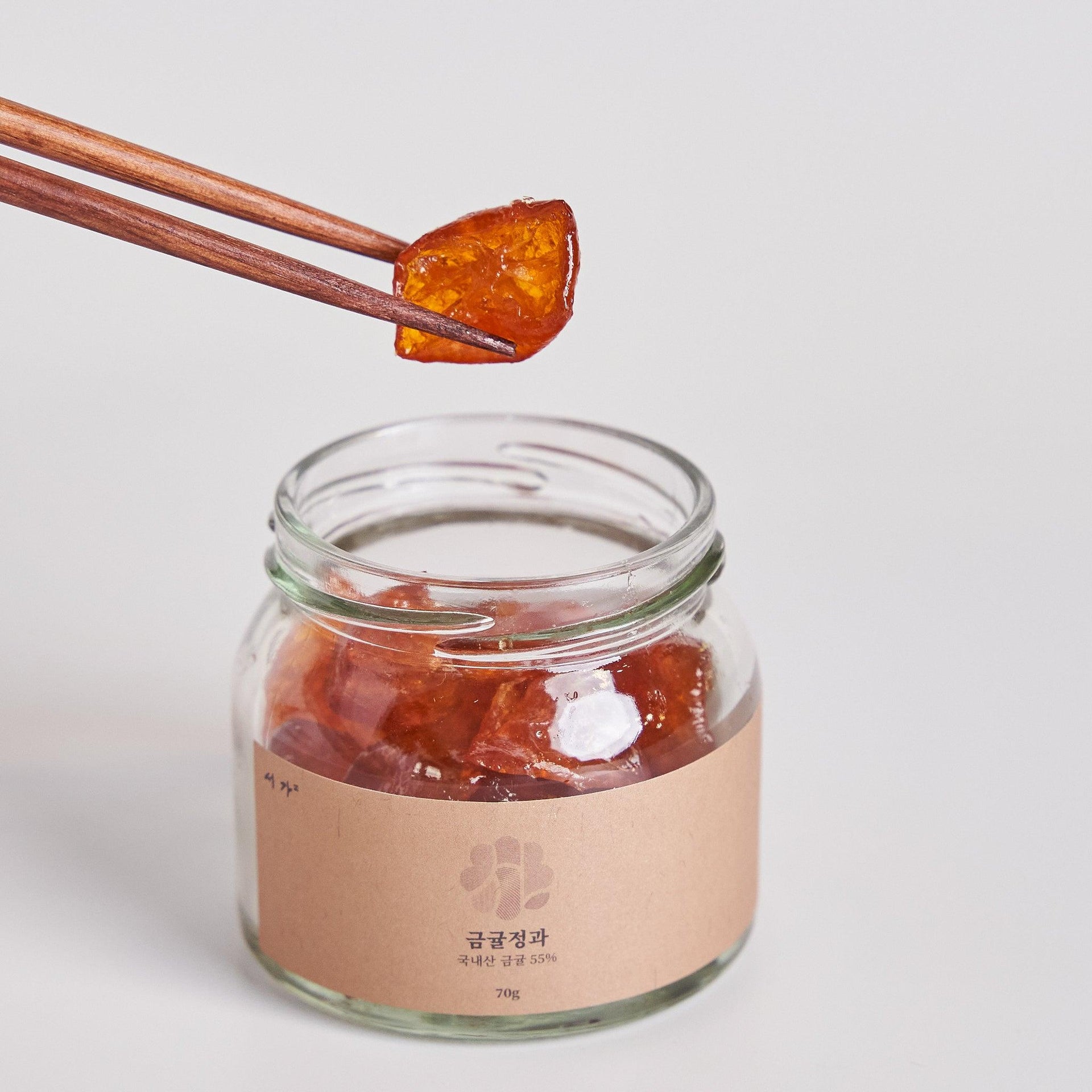 Dried kumquat jelly in glass jar with spoonful