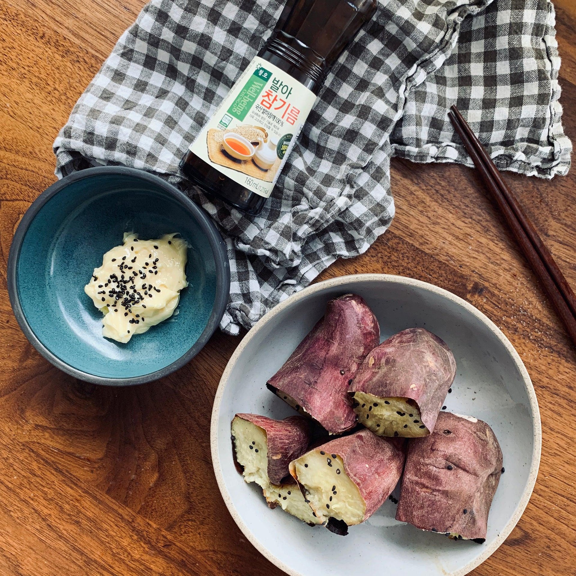 Sprouted sesame oil bottle with label beside a plate of sweet potato slices
