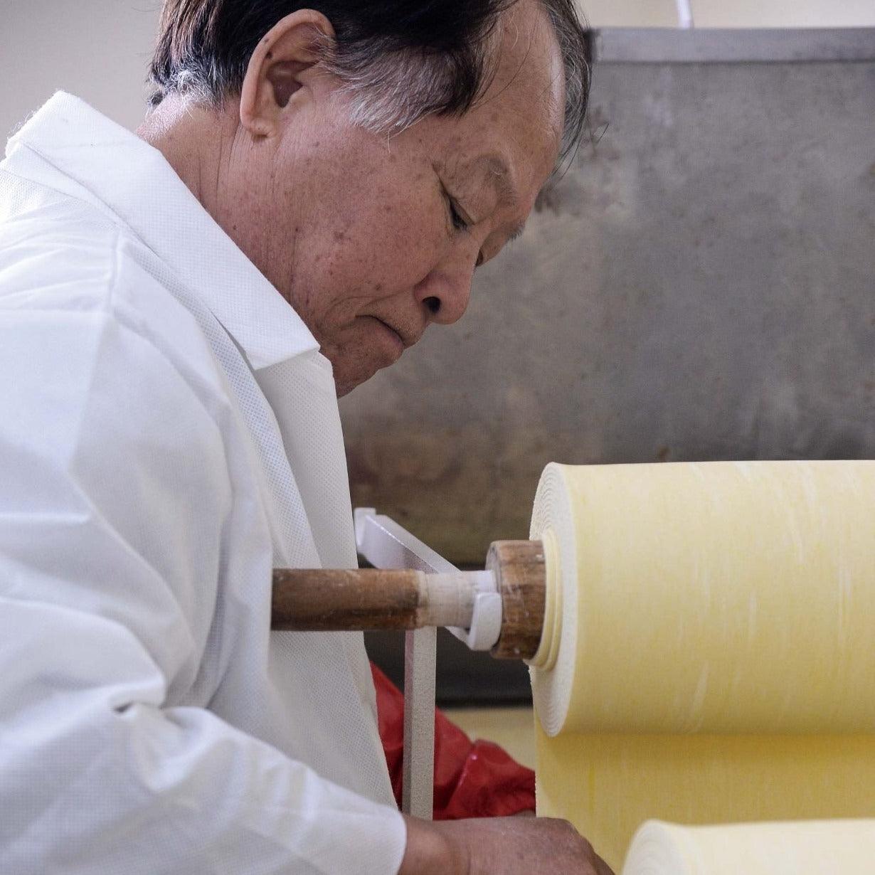 Dried noodle sheet being shaped by a machine during production
