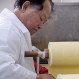Dried noodle sheet being shaped by a machine during production