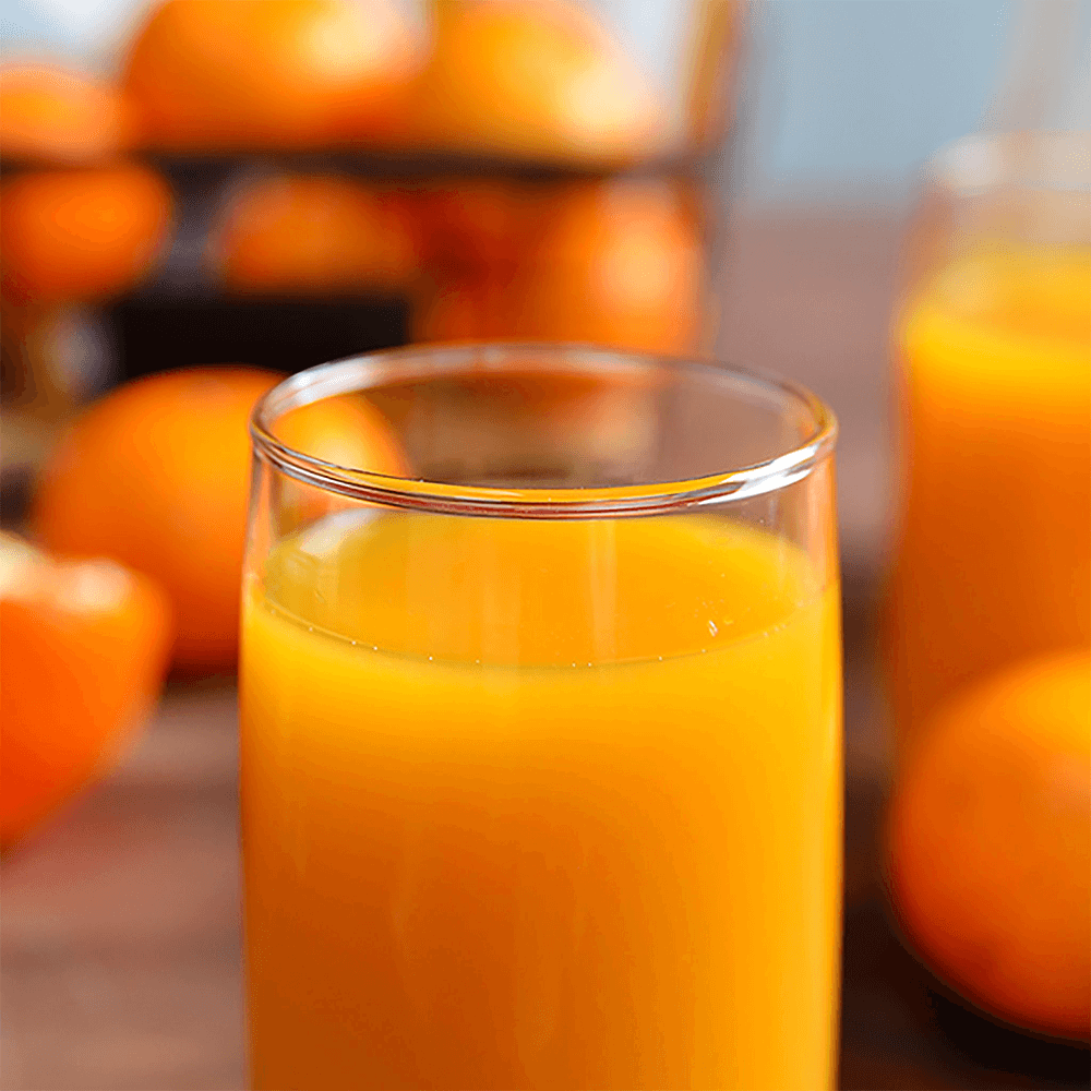 Cylindrical glass of bright orange tangerine juice