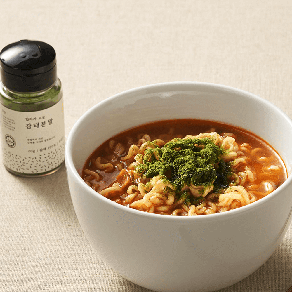 Powder jar and bowl of green soup with leafy garnish