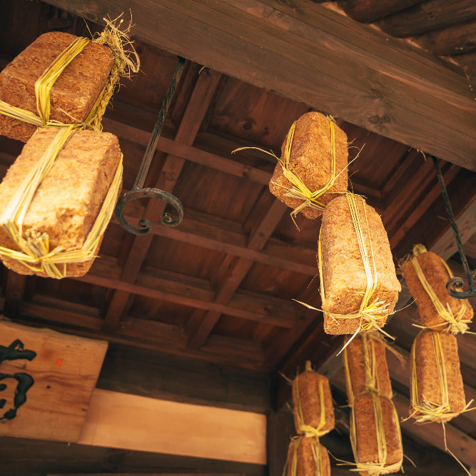 Fermented soybean paste blocks tied with yellow twine, hanging