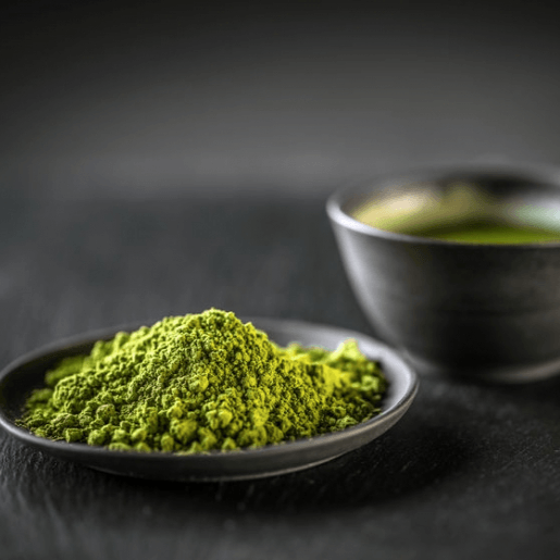 Organic green tea matcha powder in small dark bowl with bright green powder